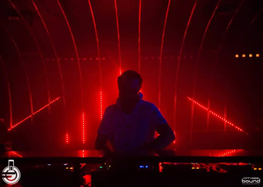 Dj performing with red lines behind him