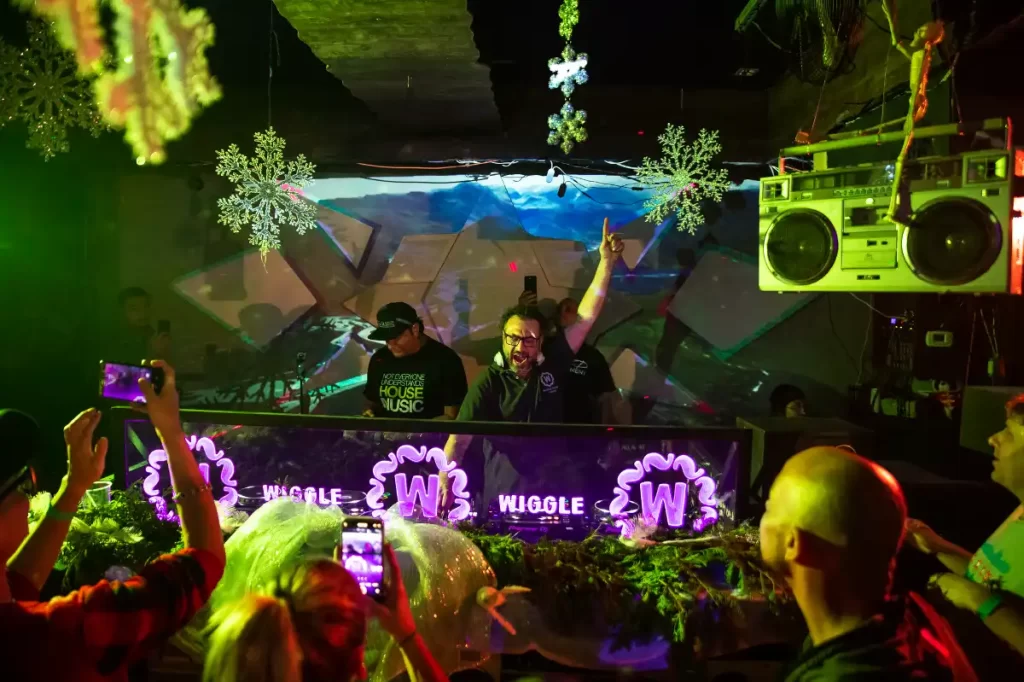 DJ with arm extended and finger to ceiling