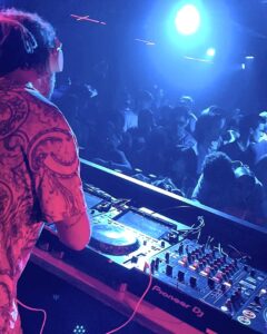 DJ with colourful shirt in neon lights