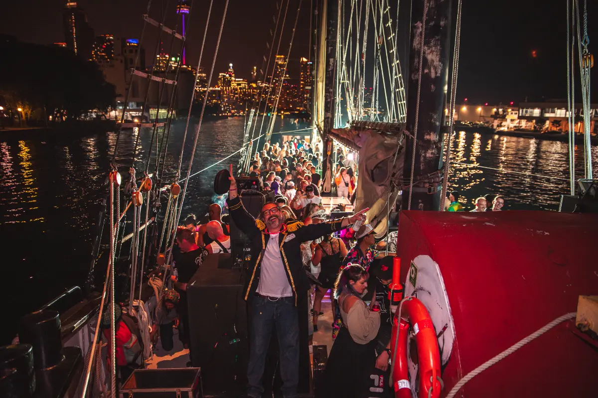DJ with hands in the air on a boat