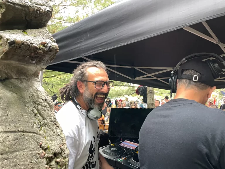 Man laughing while DJing in whote T-shirt