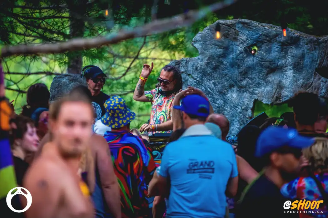 Crowd dancing to DJ in distance