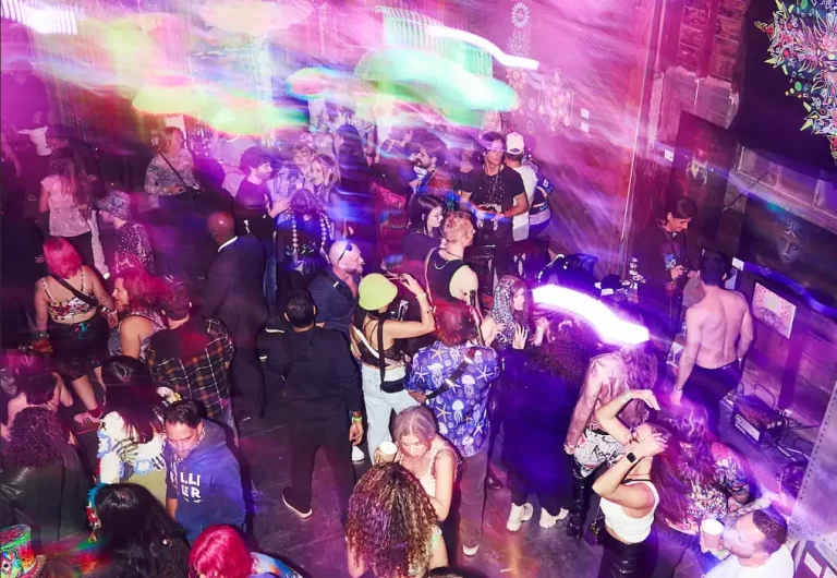 A purple neon lit room full of people